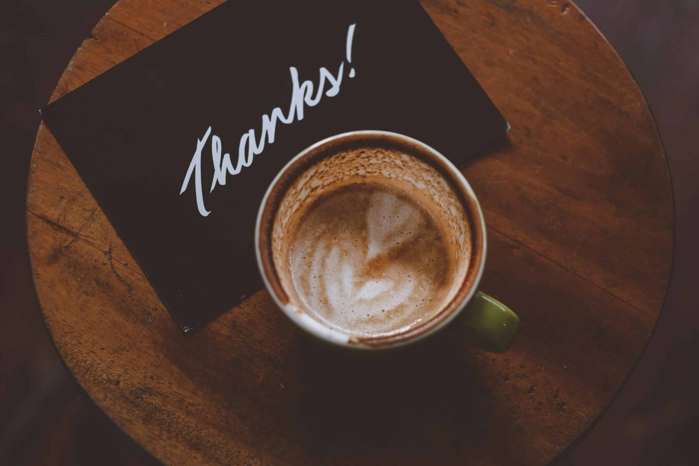 Cup of coffee with thank you note